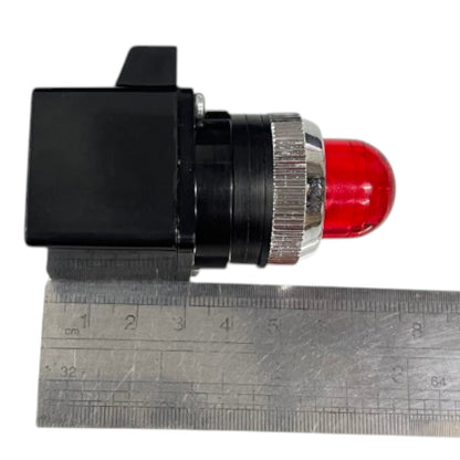 A small industrial red LED indicator light with a black plastic housing and a silver metal adjustment ring, shown next to a metal ruler for scale on a white background.