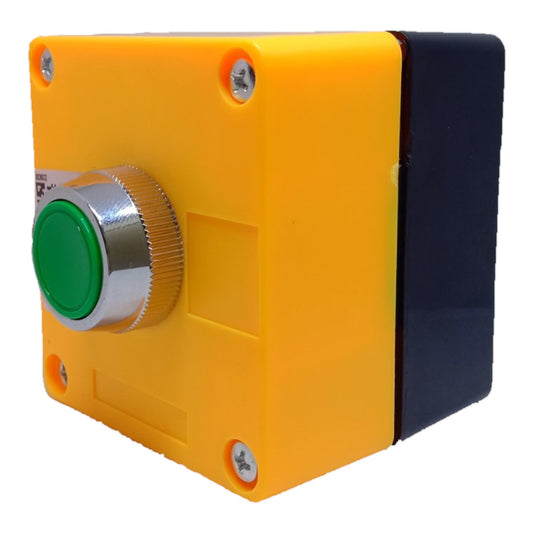 A square industrial push-button switch box with a bright yellow front casing, a green button, a silver ribbed bezel, and a dark navy blue side panel, isolated on a white background.