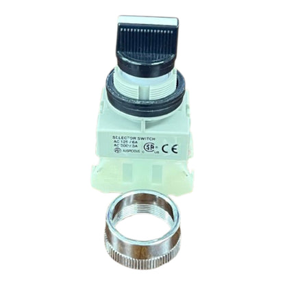 An industrial electrical selector switch with a black and white plastic body, a black ribbed top cap, and a separate silver metal threaded connector ring placed below it on a plain white background.