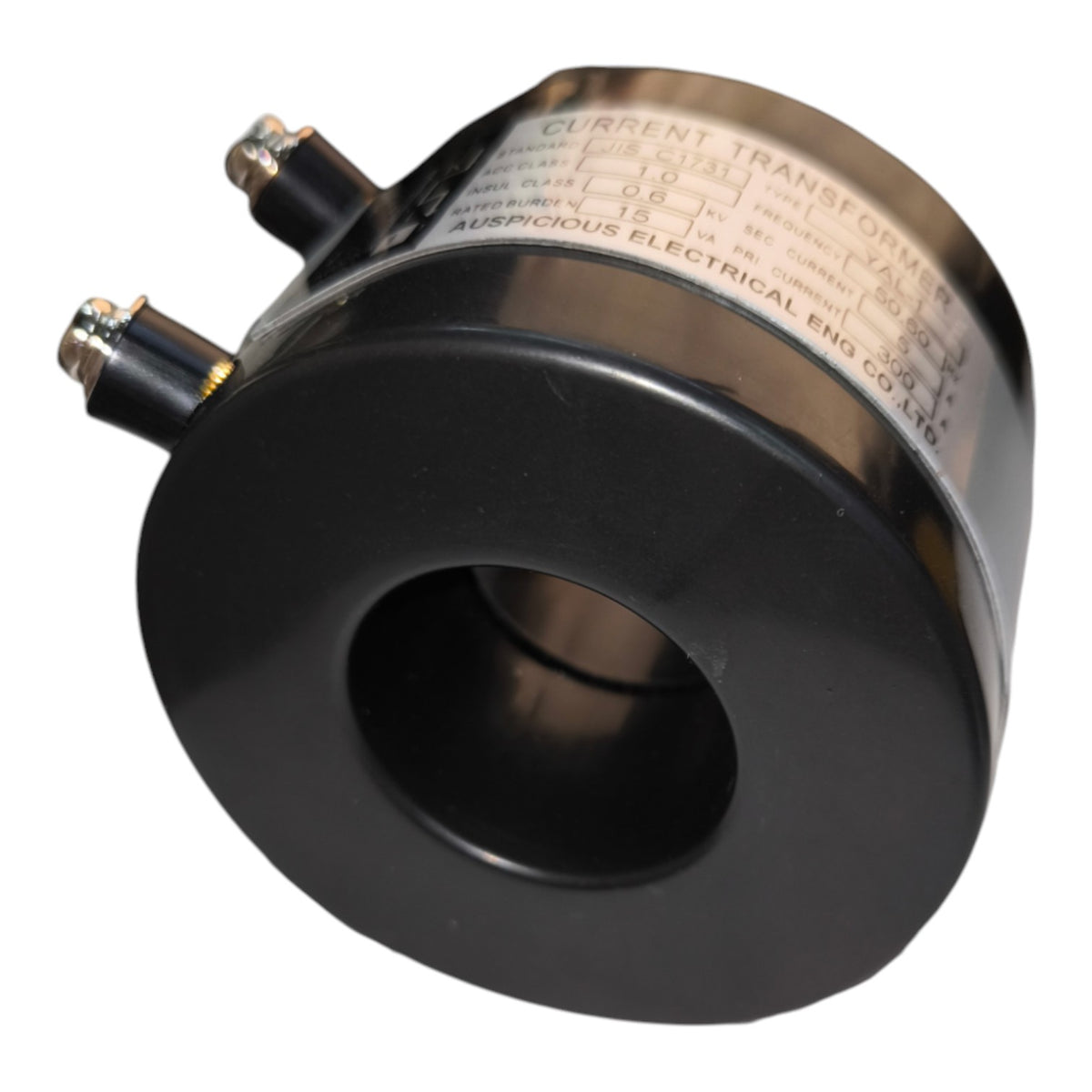A black cylindrical current transformer with a metal label showing technical specifications, photographed on a white background.