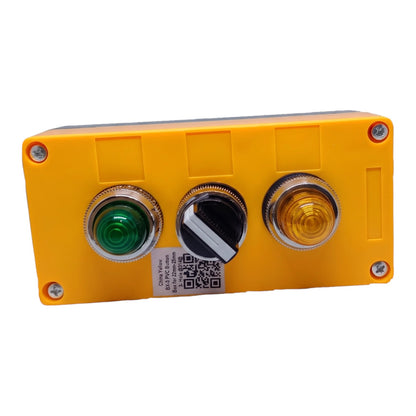 A yellow industrial control panel box with three front push buttons: a green button on the left, a black toggle switch in the center, and a yellow indicator light on the right. The panel is secured with corner screws and has a small QR code label on the front.