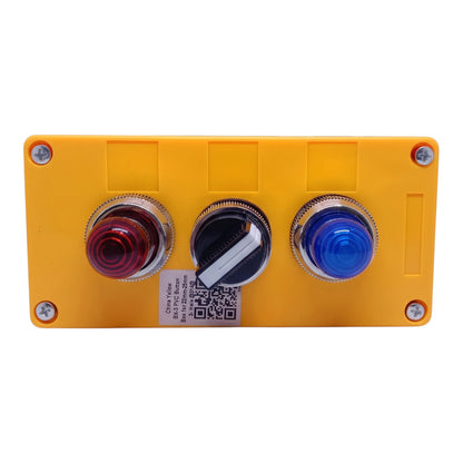 A yellow industrial control panel featuring three round push buttons: a red light button on the left, a black rotary switch in the center, and a blue light button on the right, all mounted on a yellow plastic faceplate with silver screws.