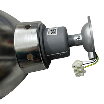 A close-up of a metal and gray electrical component with a small white connector and wire leads, shown on a plain white background.