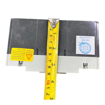 A black industrial electrical component with a yellow tape measure stretched vertically across it to show dimensions, on a plain white background.