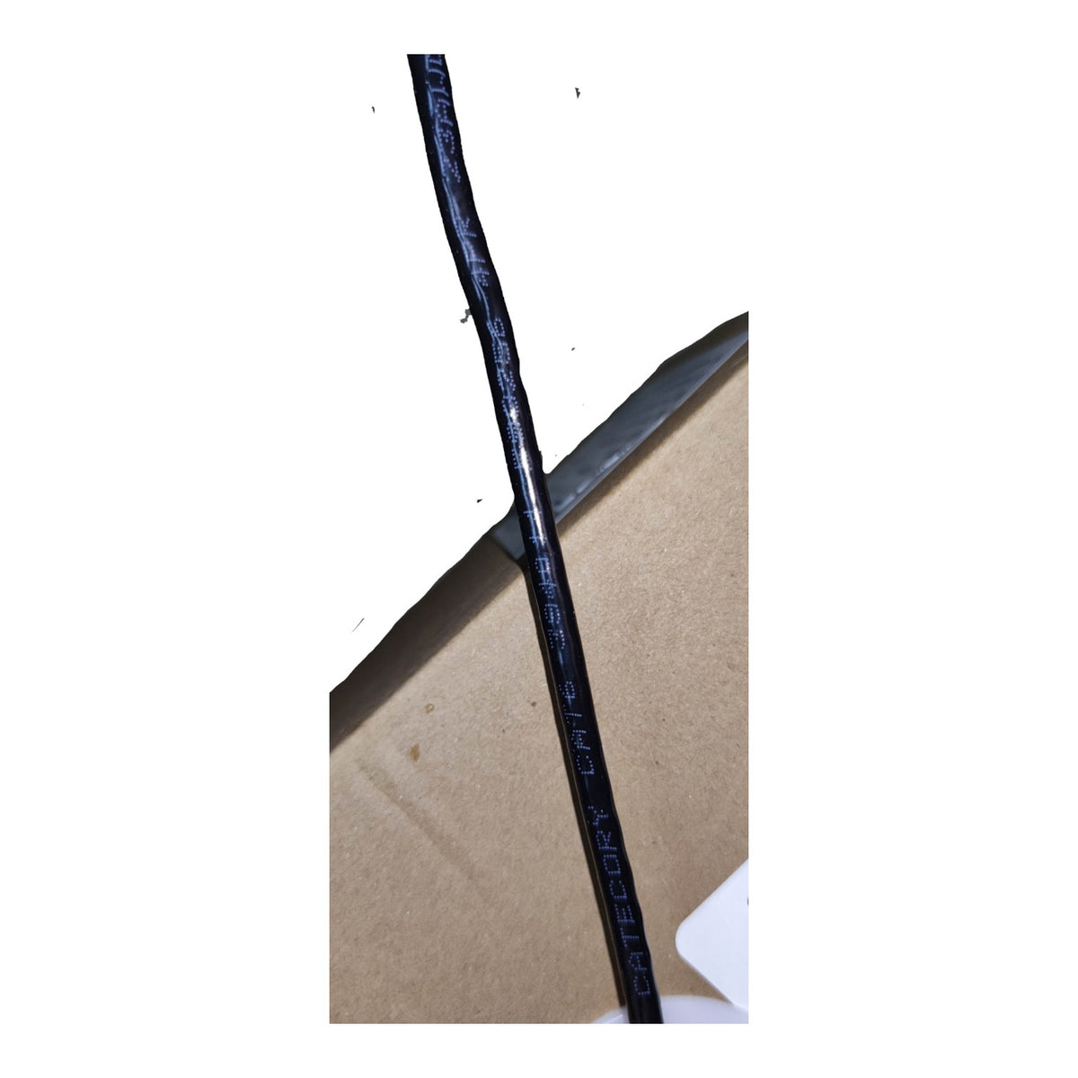 A close-up of a black cable with blue printed text reading 'CATPOKY' and '4-core 2.4mm' resting on a brown cardboard surface.