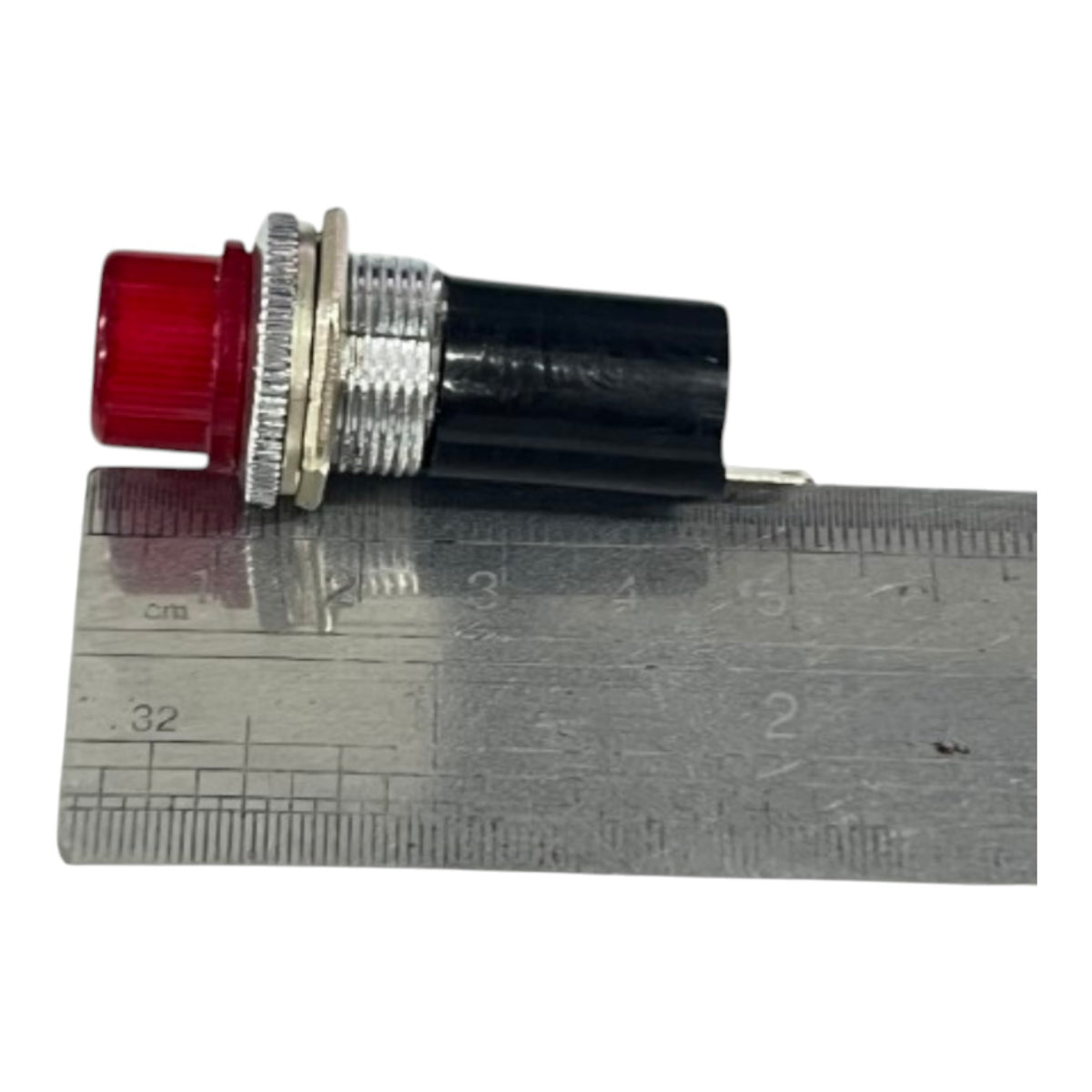 An industrial push-button switch with a red translucent lens, silver metal threaded housing, and a black plastic body, shown next to a metal ruler for scale.