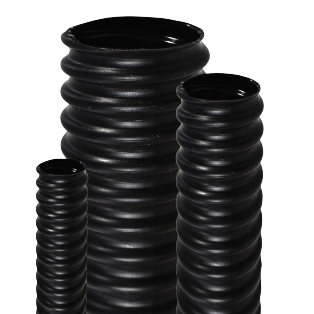 Three black ribbed ceramic vases of different heights arranged on a white background.