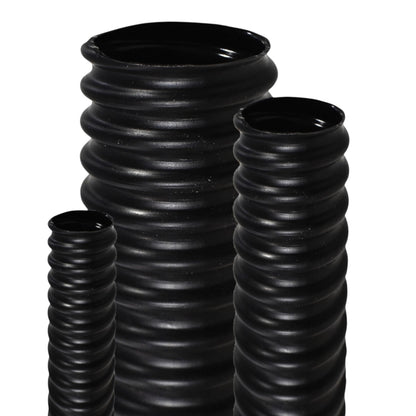 Three black ribbed ceramic vases of different heights arranged on a white background.