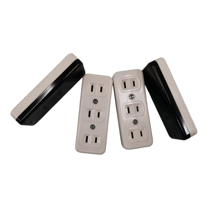 Four rectangular outlet covers or electrical faceplates shown on a plain white background, with two front views and two side views. The front faces are warm off-white/cream, and the sides are black.