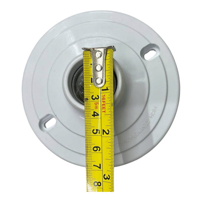 A white circular electrical ceiling mount socket with a yellow tape measure inserted vertically to show its dimensions, on a solid white background.