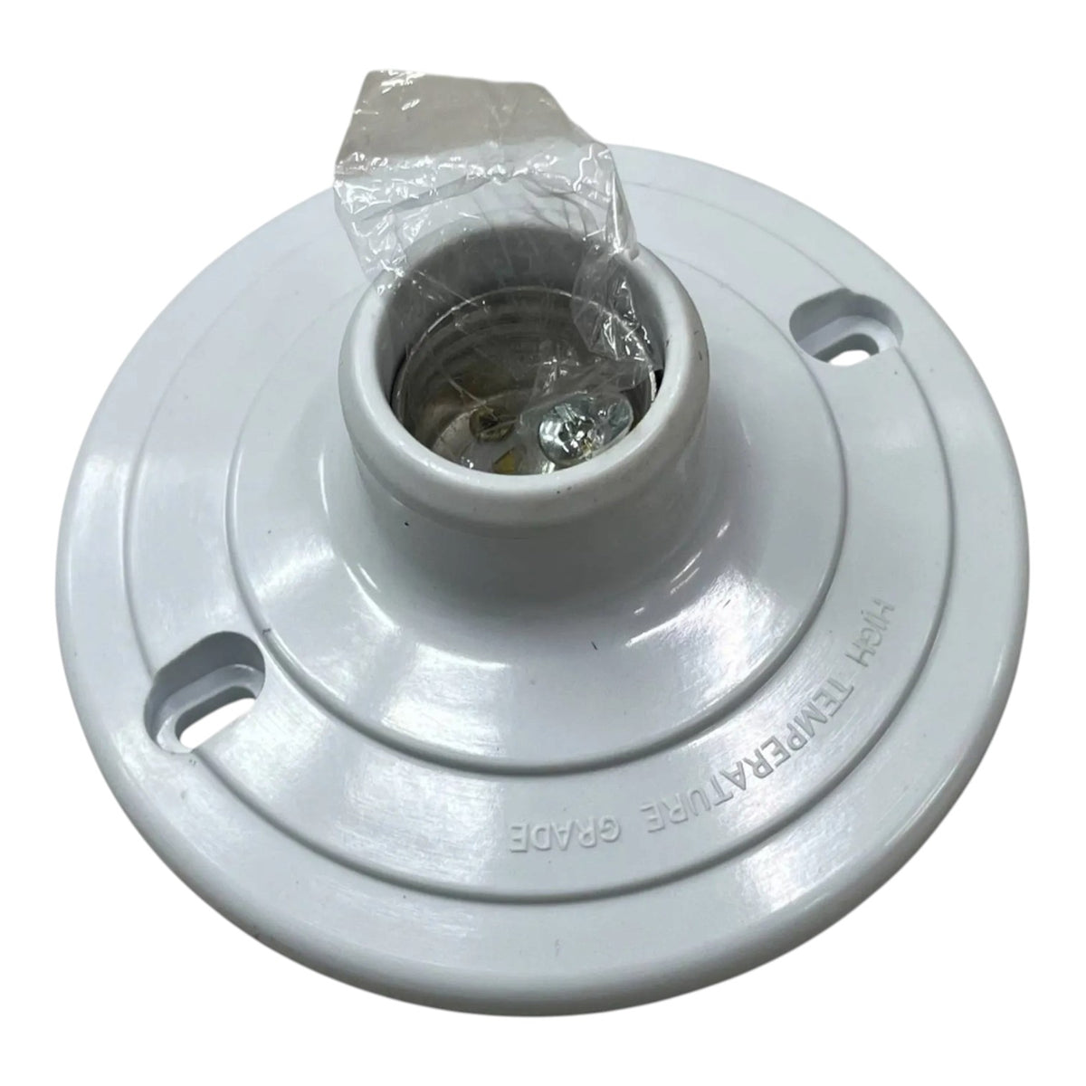 A white plastic light fixture base or ceiling canopy with a central socket opening, visible mounting holes, and a small piece of clear plastic wrapping around the top opening, shown on a white background.