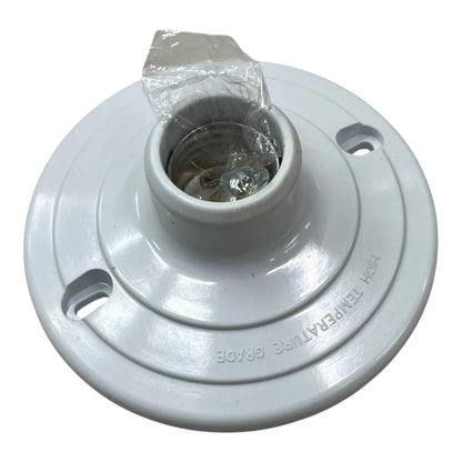 A white plastic light fixture base or ceiling canopy with a central socket opening, visible mounting holes, and a small piece of clear plastic wrapping around the top opening, shown on a white background.