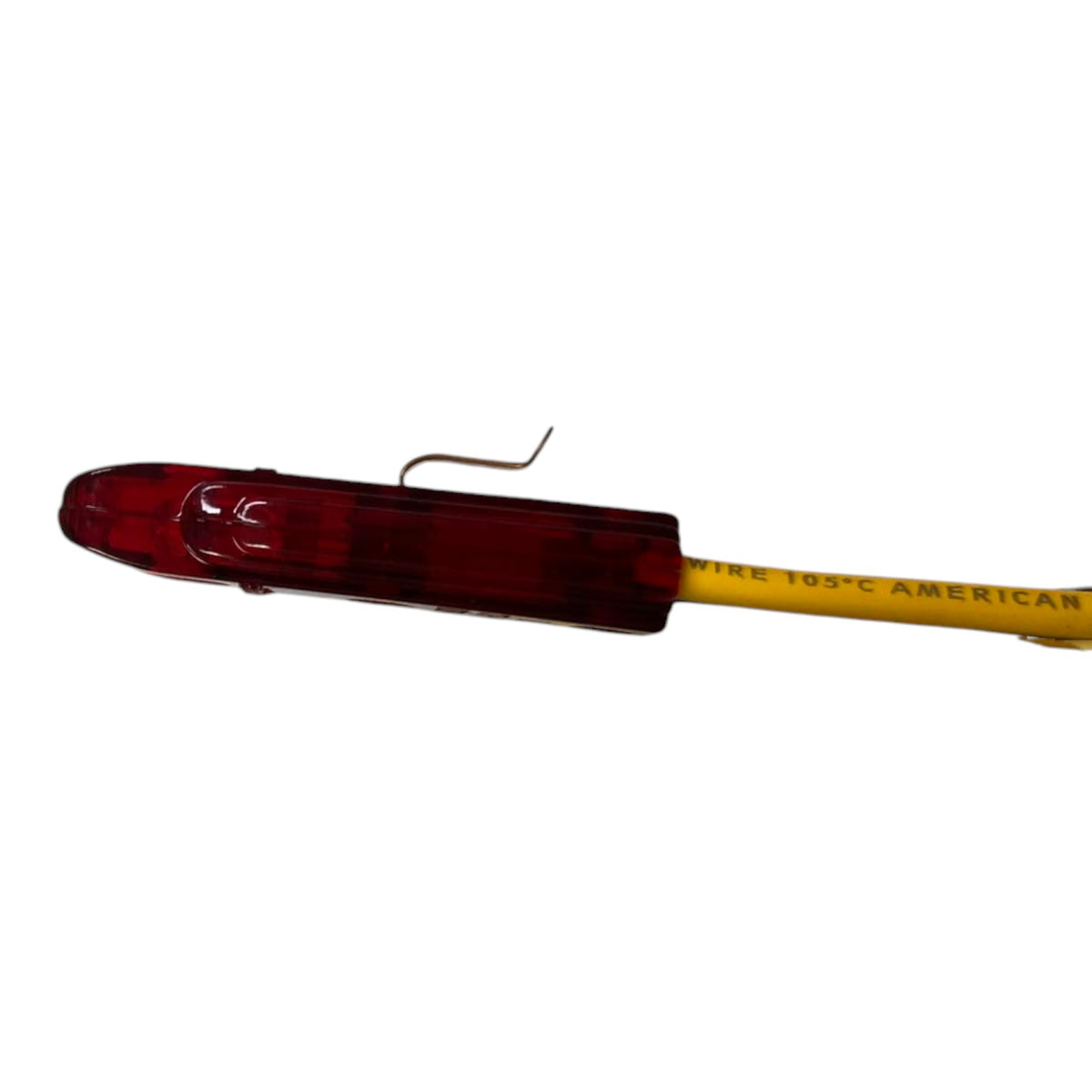 A red plastic light housing attached to a yellow wire with printed text, shown against a plain white background.