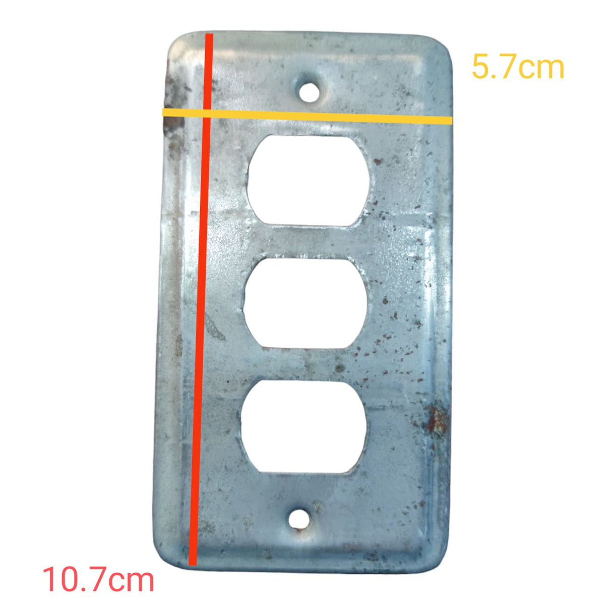 A weathered metal three-outlet electrical wall plate shown on a white background with red and yellow measurement lines and text indicating dimensions 10.7cm and 5.