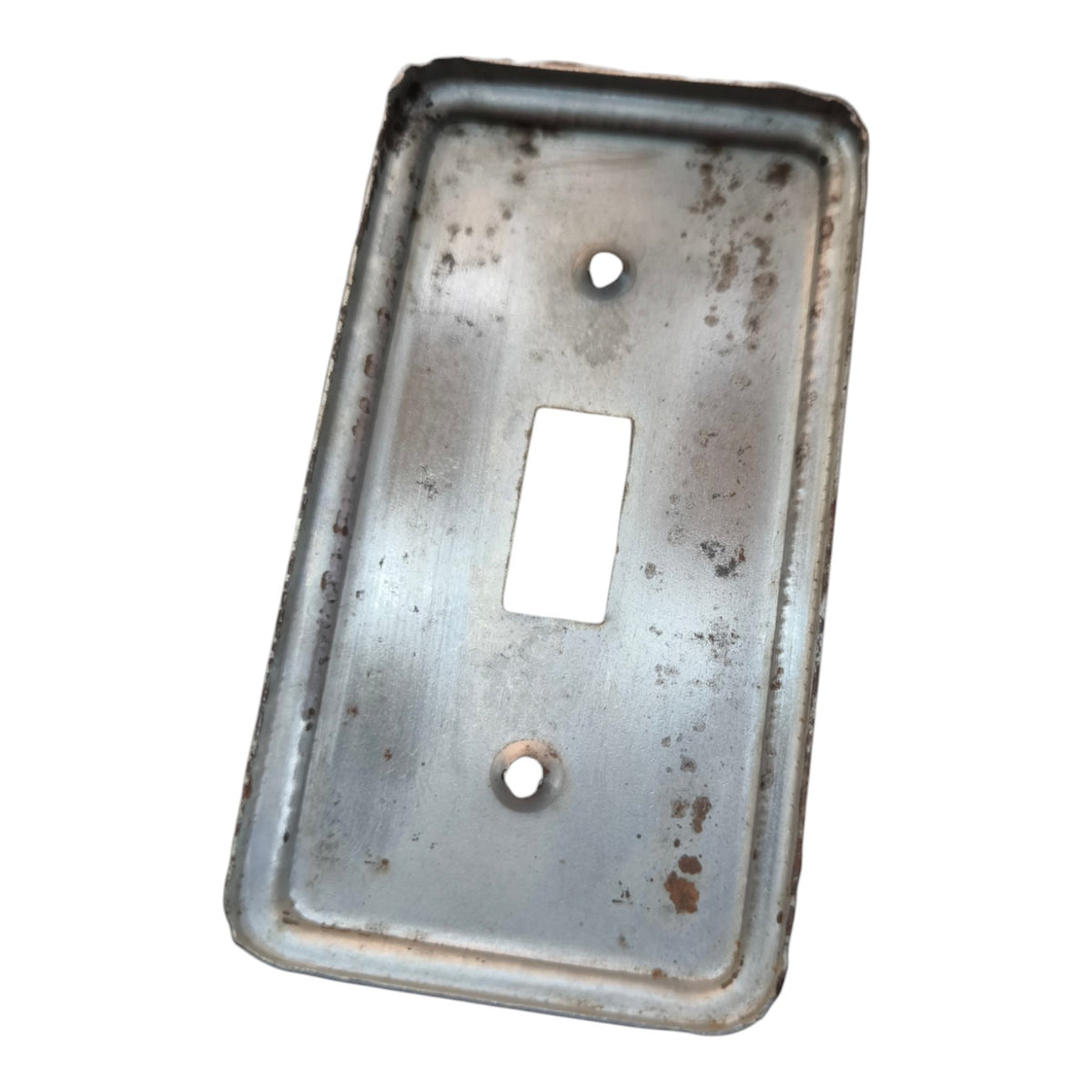 A rectangular vintage metal light switch plate cover with a single toggle cutout and two screw holes, showing signs of rust and age on a plain white background.