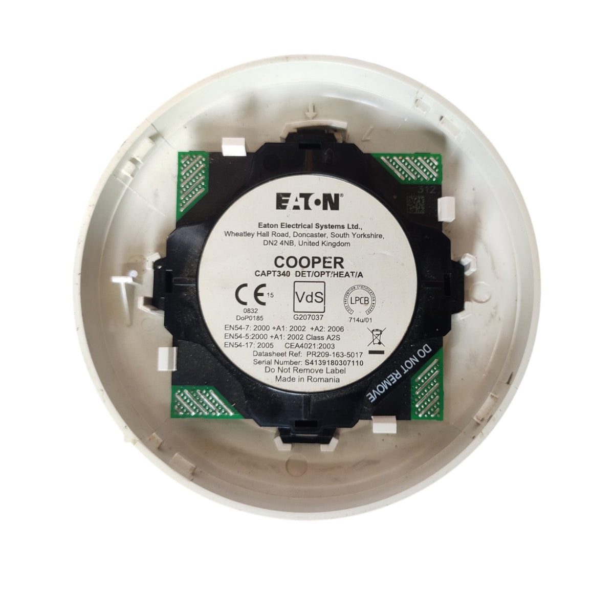 A close-up of a Cooper Captain 230V Class AIs electrical component inside a white circular housing, showing the black and green circuit board with a white label.