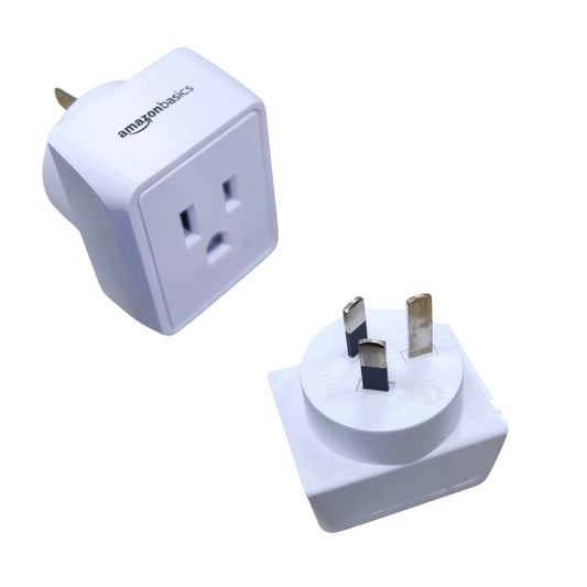 Two white Amazon-branded travel adapter plugs shown on a plain white background, one displaying the US outlet and the other showing the UK three-pin plug.