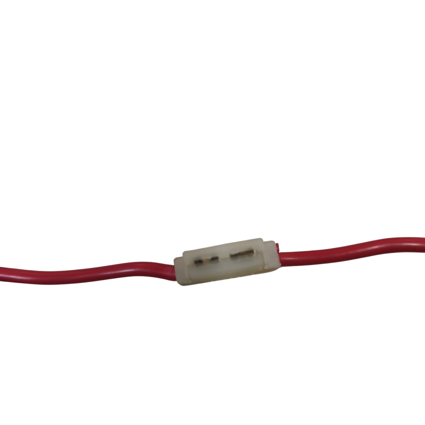 A close-up of a red wire or cable passing through a small translucent off-white plastic connector on a plain white background.