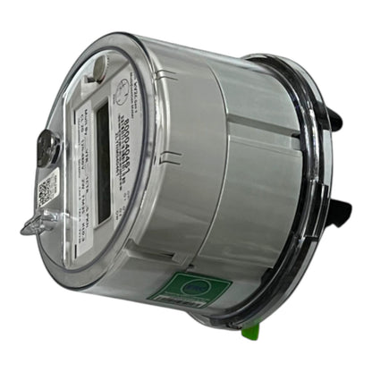 A digital electricity meter with a metallic silver body, clear protective casing, a digital display window, and a green safety label, shown on a plain white background.