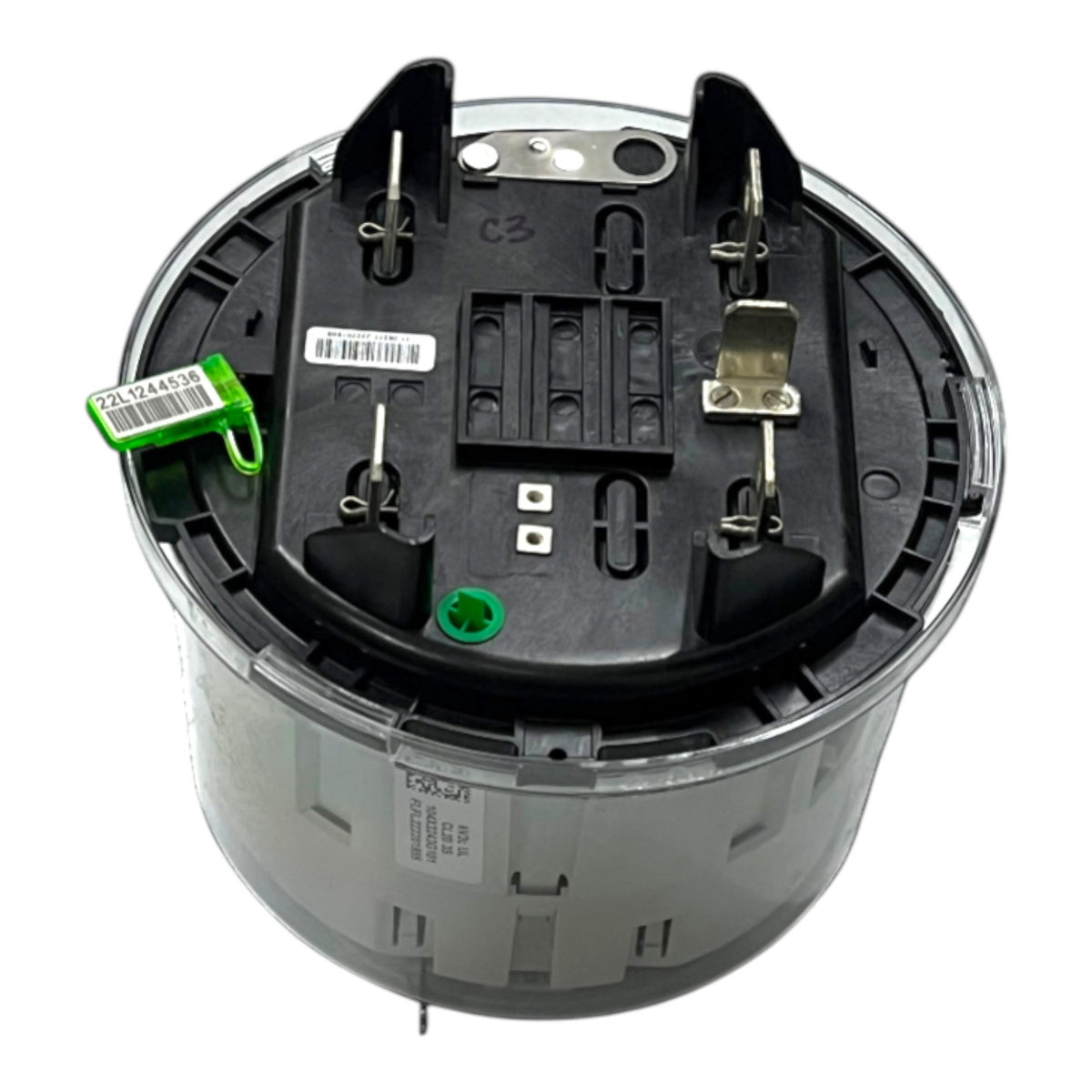 A circular automotive fuel pump assembly or similar mechanical part, showing the underside with black plastic components, metal terminals, a green tag, and a gray outer casing on a white background.