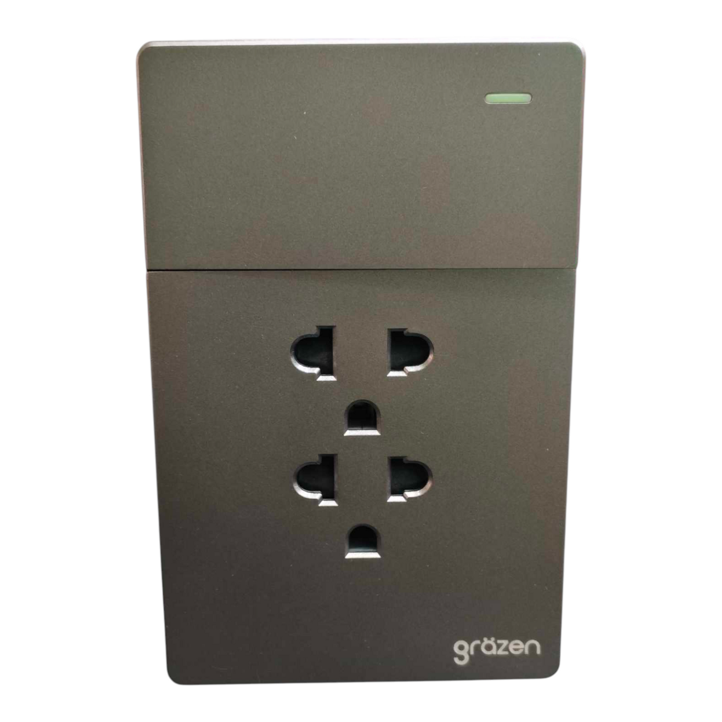 A dark gray wall outlet cover with a single UK three-pin socket visible, featuring the 'grözen' brand logo in the bottom right corner.