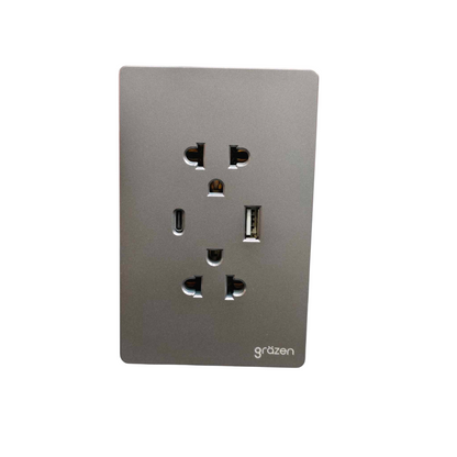A modern wall outlet panel featuring a dual USAC outlet and one USB-C port, finished in a brushed metallic gray with the 'gräzen' brand name printed at the bottom right.