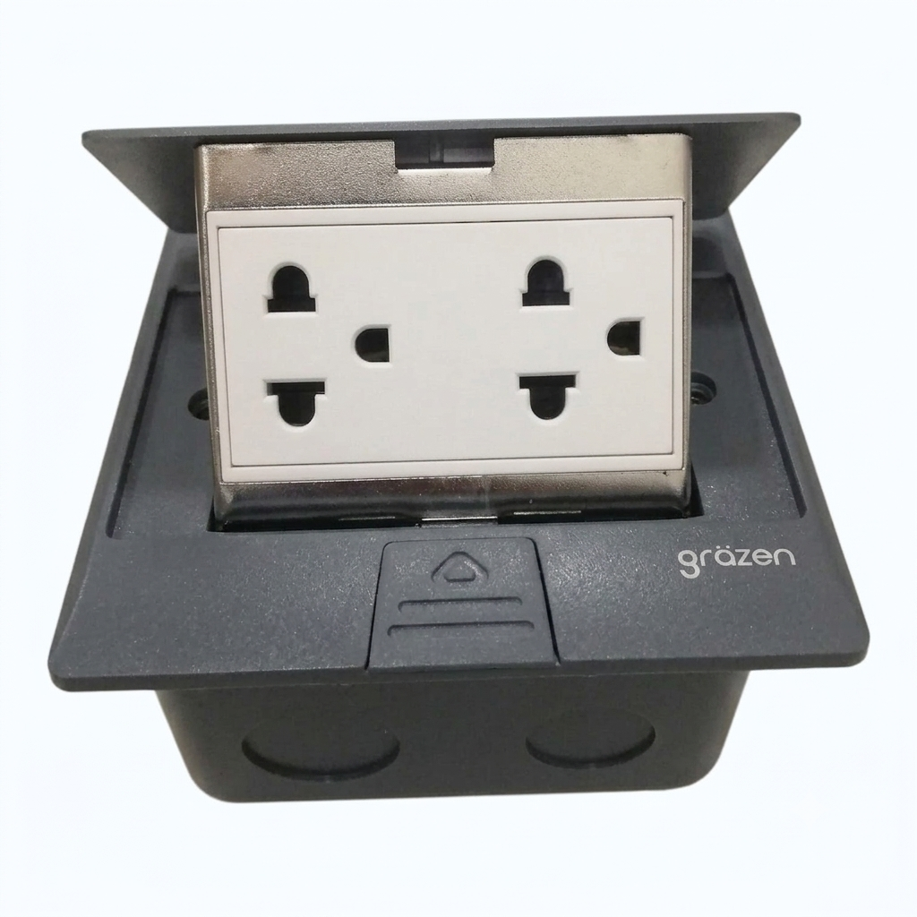 A black waterproof electrical outlet cover with a white four-pin UK wall socket visible inside, shown on a plain white background. The brand name 'gräzen' is printed on the front.