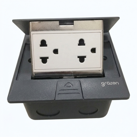 A black waterproof electrical outlet cover with a white four-pin UK wall socket visible inside, shown on a plain white background. The brand name 'gräzen' is printed on the front.
