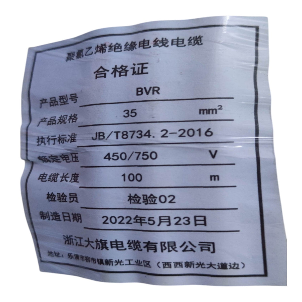 A close-up of a white paper certificate label with black printed Chinese text and table lines, wrapped in clear plastic. The label includes product type BVR and manufacturer Zhejiang Daqi Cable Cable Co.