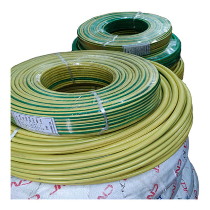 Coiled yellow and green cable or wire rolls wrapped in clear plastic, stacked on a white woven carrier bag against a plain white background.