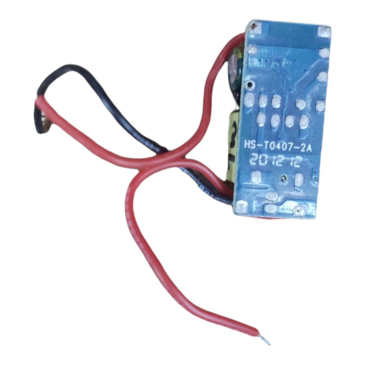 A small electronic component with a blue printed circuit board and two attached wires, one red and one black, on a plain white background.
