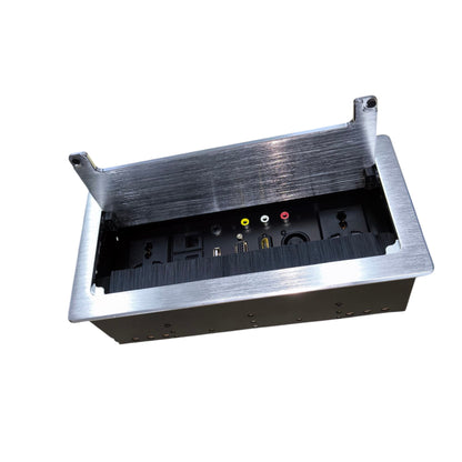 A brushed metal under-desk power strip with a hinged lid open to reveal internal outlets and audio/video connectors, shown on a plain white background.