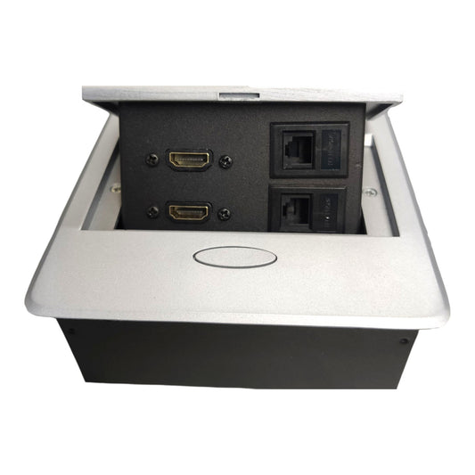 A pop-up under-desk power outlet box with a silver metallic outer frame and a black interior showing HDMI ports and power sockets, isolated on a white background.