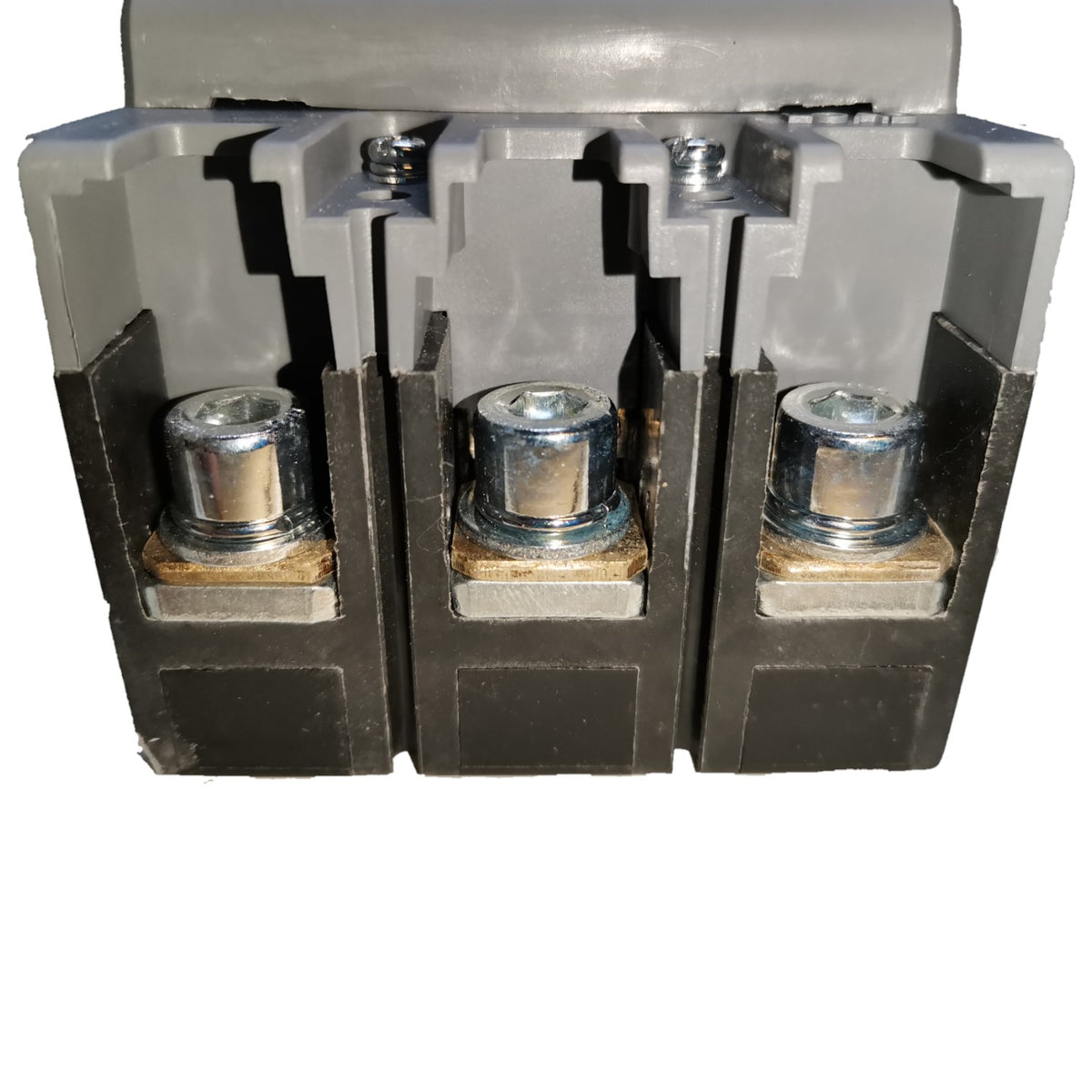 A close-up of a three-terminal electrical terminal block connector with gray plastic housing and three exposed metal screw terminals on a white background.