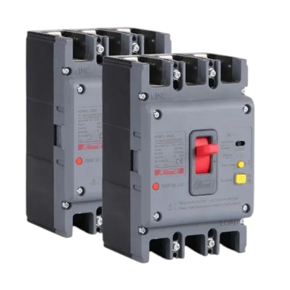 Two industrial electrical contactors shown on a plain white background, with the front unit in sharp focus and a second unit behind it at an angle. The contactors are dark gray with a red switch handle, small red and yellow indicator lights, and printed technical labels.