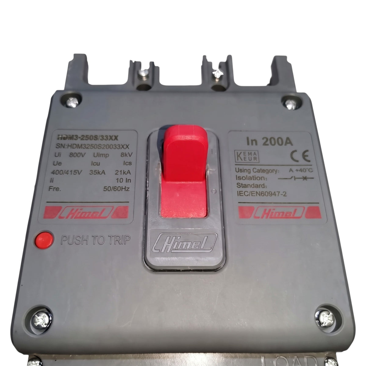 A Himpel industrial circuit breaker with a gray plastic housing, a prominent red central switch, a red push-to-trip button, and technical specifications printed on the front.