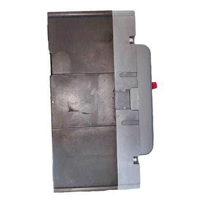 A heavy-duty industrial metal component, likely a valve body or filter housing, featuring a dark gray cast metal face, a silver-gray side casing, and a small red release button.