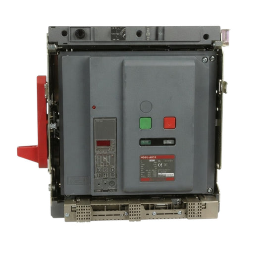 A large industrial electrical switchgear unit with a gray metal casing, featuring a red handle on the left, green and red buttons on the front, and a red and black label near the bottom.