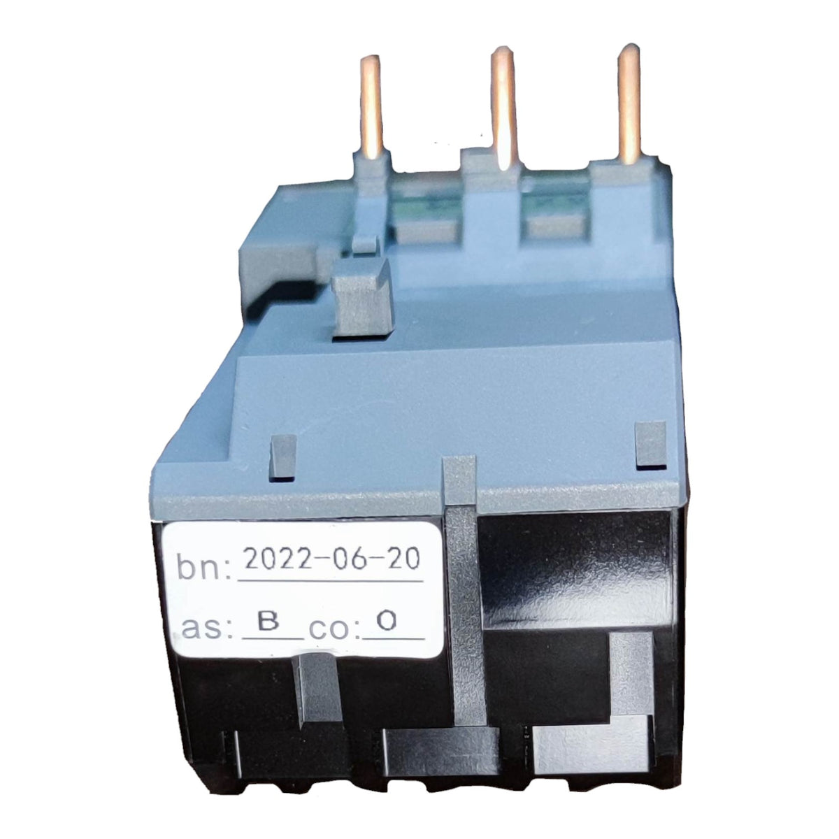 A small industrial electrical component with a gray top housing, black base, three copper-colored pins on top, and a white label on the front.