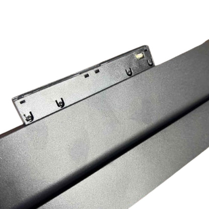 Close-up of a dark gray or black metal panel with a small mounting bracket attached, photographed on a plain white background.