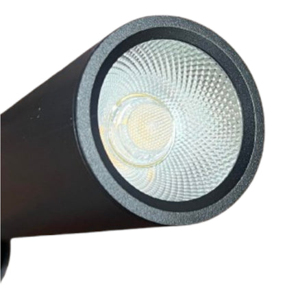 Close-up of a black cylindrical LED spotlight or lamp head with a textured clear lens and visible warm yellow LED chip, isolated on a white background.