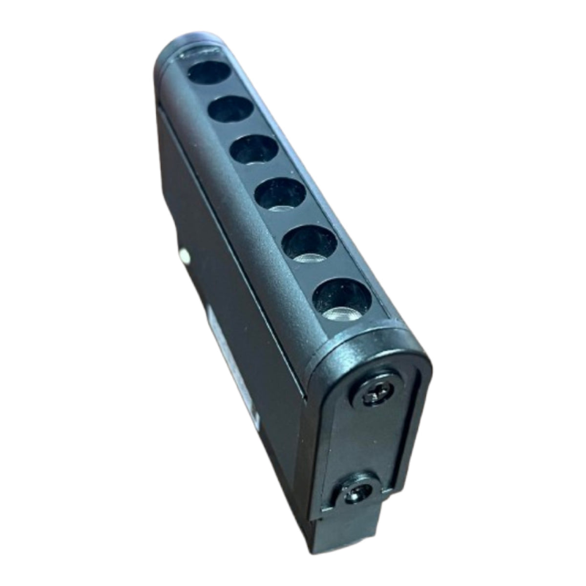 A black plastic multi-port connector block with six circular ports, shown at an angle on a plain white background.