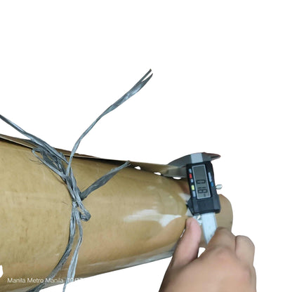 Digital caliper measuring a cylindrical object wrapped in wire on a white background