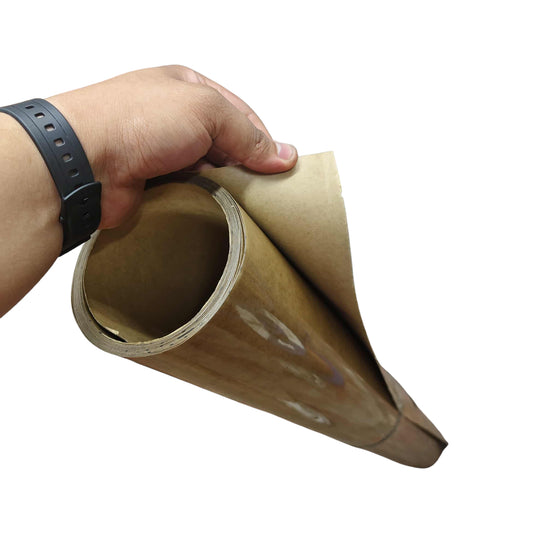 Hand holding a roll of brown paper on a white background