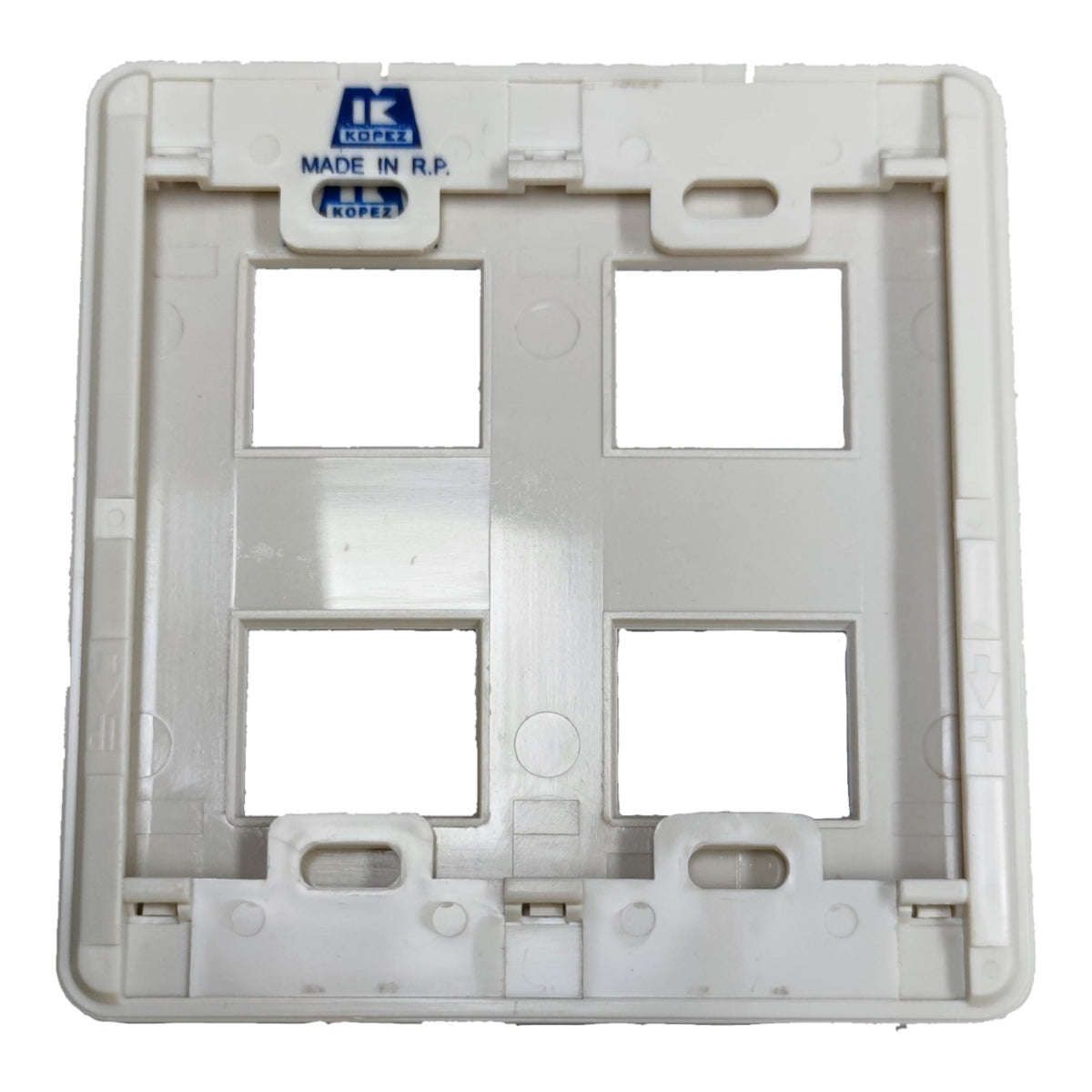 A white plastic four-guillotine wall switch plate backplate with a blue 'IK COPEZ MADE IN R.P.