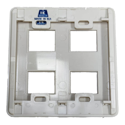 A white plastic four-guillotine wall switch plate backplate with a blue 'IK COPEZ MADE IN R.P.