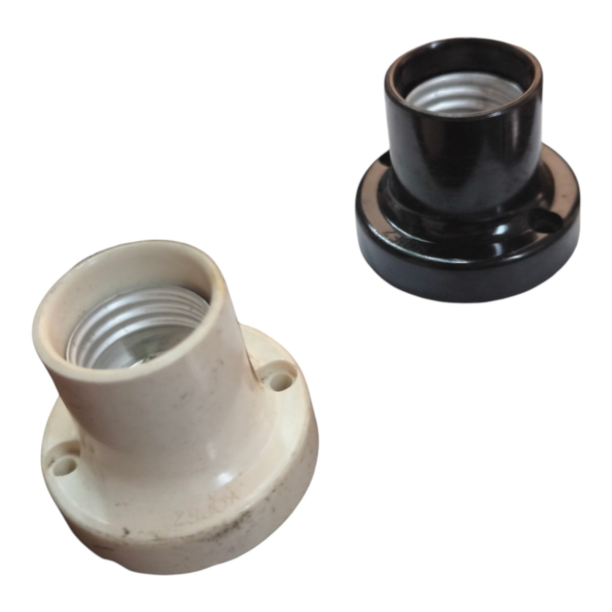 Two ceramic light bulb socket adapters on a white background, one in a warm off-white/cream color and one in glossy black.