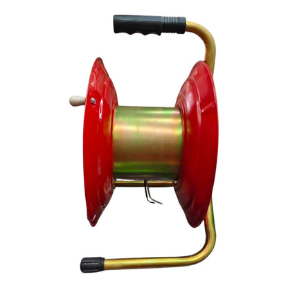 A metal cable reel with red plastic spool flanges, a gold-colored central body, and black handles on the top and bottom, shown against a plain white background.