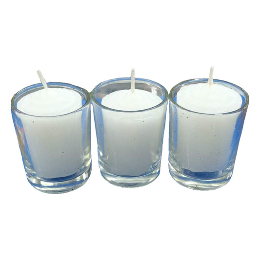 Three white candles in clear glass holders on a white background