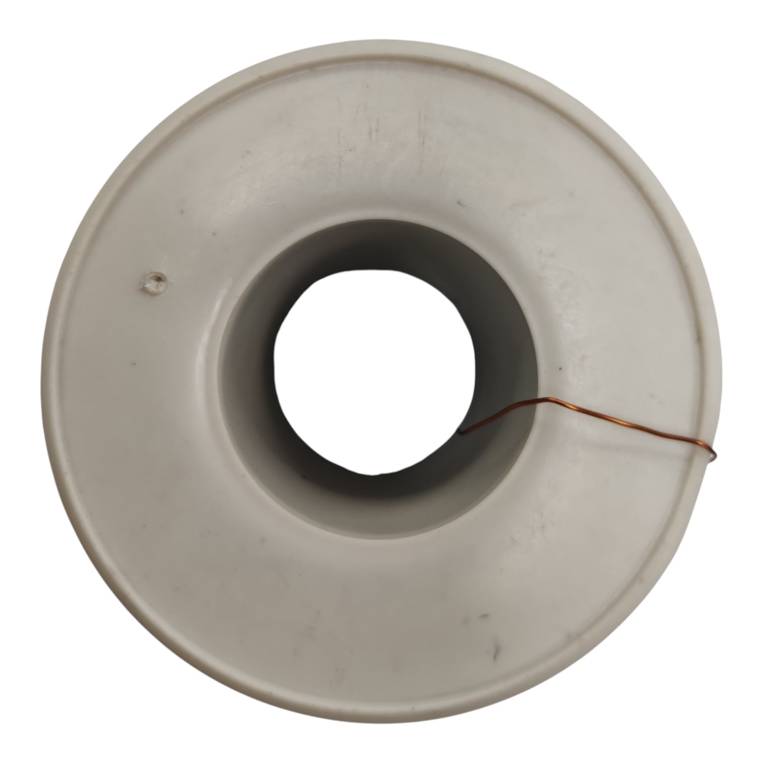 A circular off-white plastic or ceramic ring-shaped component with a central hole and a thin copper wire wrapped around it, shown on a plain white background.